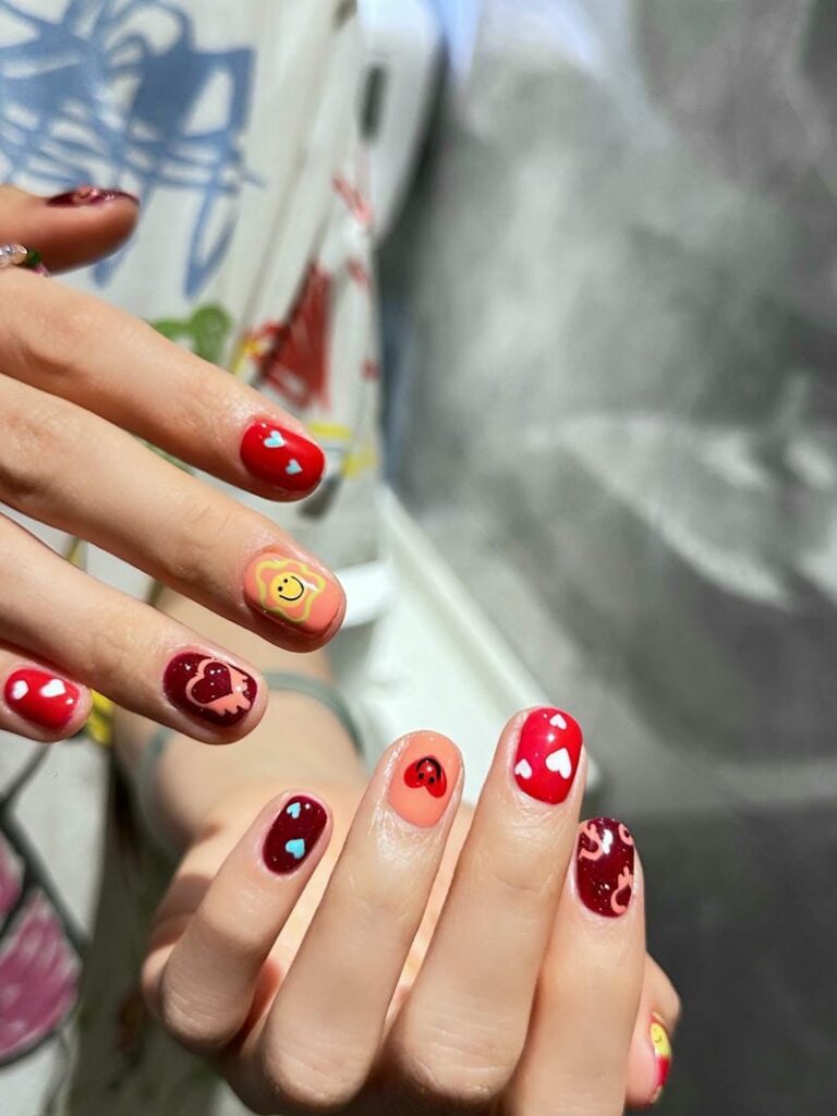 Mẫu nail mặt cười đẹp, dễ thương: Gợi ý hot trend năm 2025 Mau Nail Ve Mat Cuoi Tone Do Noi Bat Sang Tay 768x1024