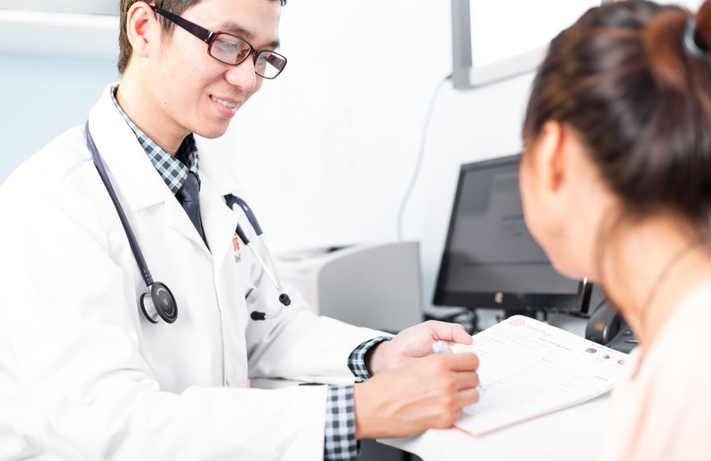 Bàn chân đang được bác sĩ thăm khám, nhấn mạnh tầm quan trọng của việc đi khám khi máu bầm ở móng chân trở nên nghiêm trọng.