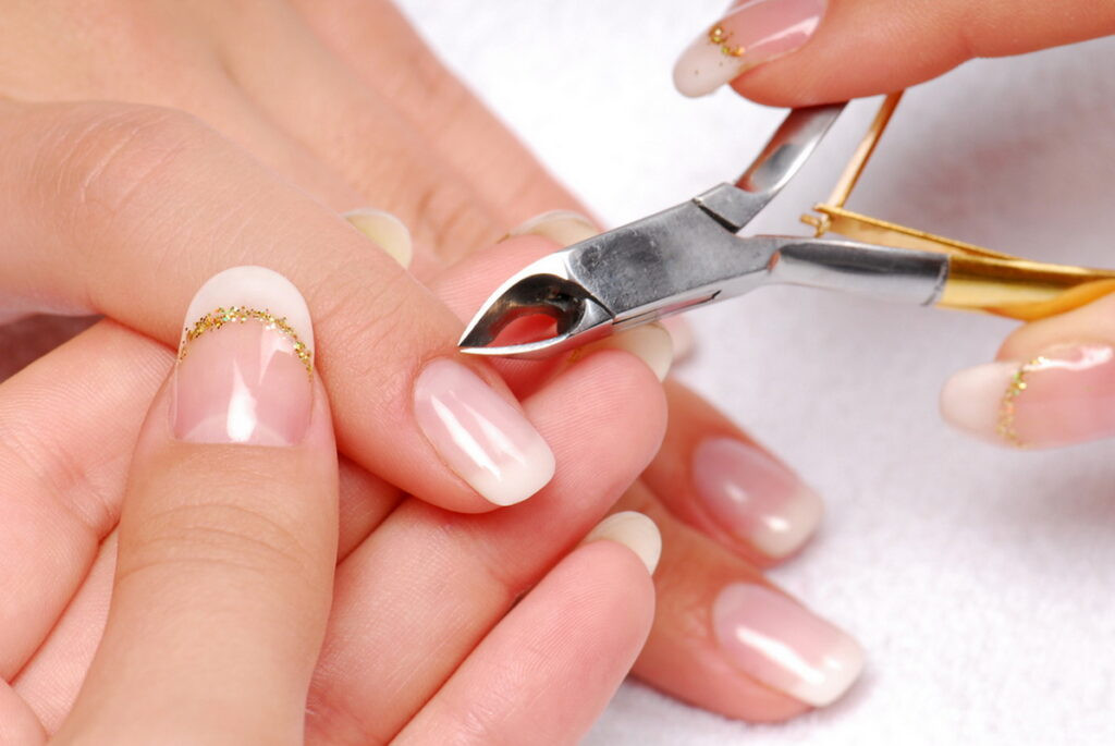 Bàn tay cầm kìm cắt móng, chuẩn bị cắt tỉa móng chân, biểu tượng của sự chăm sóc vệ sinh cá nhân