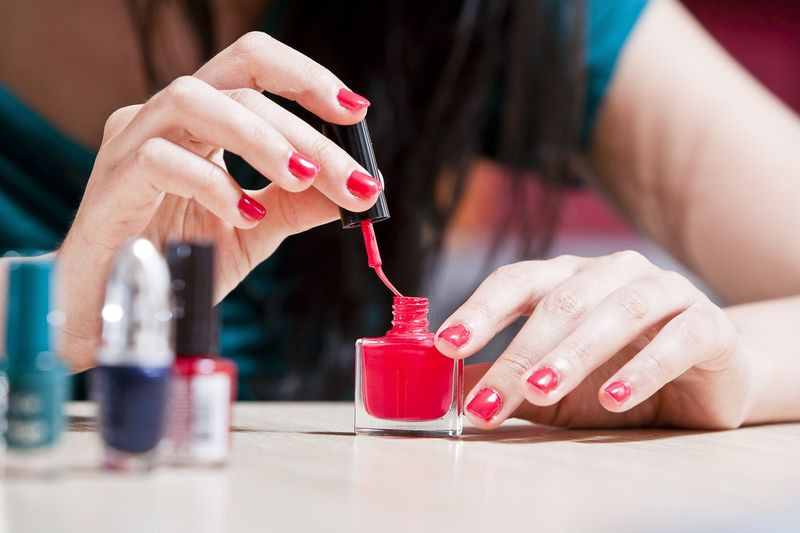 Bàn tay của mẹ bầu đang được chăm sóc móng, kèm theo các lưu ý quan trọng khi sơn móng tay để đảm bảo an toàn.
