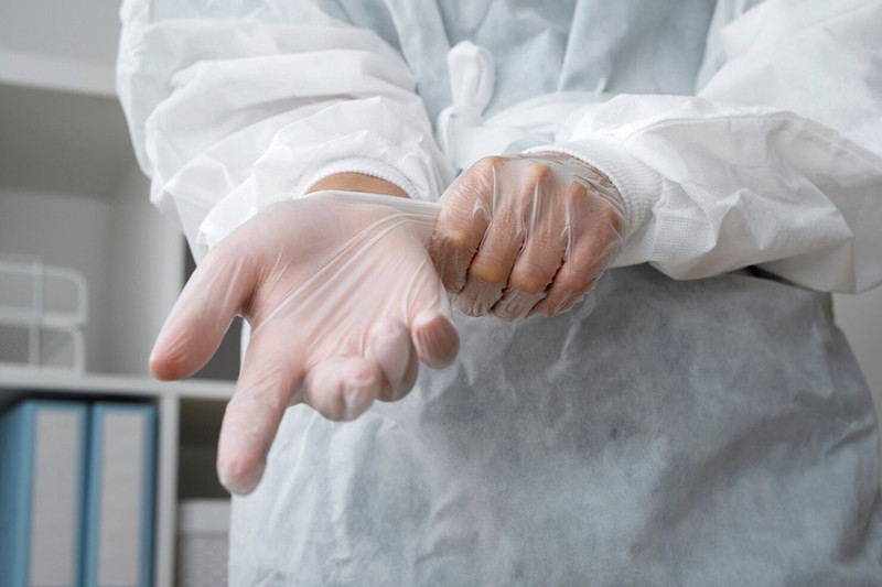 Dũa Móng Tay Có Hại Không? Sự Thật Từ Chuyên Gia Ảnh Nail Bàn tay được đeo găng tay bảo hộ, minh họa tầm quan trọng của việc bảo vệ móng khi tiếp xúc với hóa chất