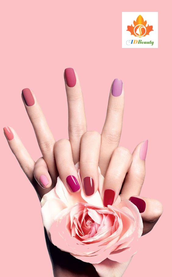 Bàn tay được làm nail màu đỏ nổi bật, tạo dáng giữ chặt cổ tay, thể hiện sự mạnh mẽ và quyến rũ