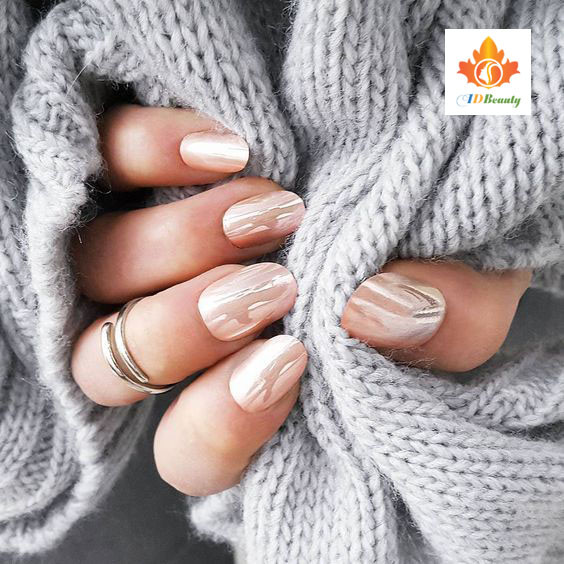 Bàn tay được làm nail màu xanh mint, tạo dáng nhẹ nhàng trên trang sách có chữ viết cổ điển, tạo cảm giác thanh lịch