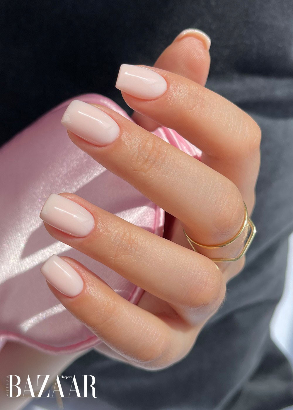 Bàn tay với bộ móng tay gel màu nude sang trọng, thể hiện sự bền đẹp của các mẫu sơn gel.