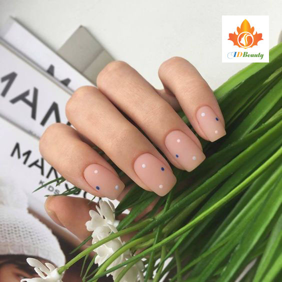 Bàn tay với bộ móng tay màu đỏ tươi, tạo dáng ôm mặt, tạo sự ấm áp và cuốn hút