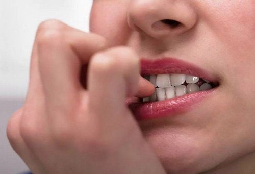 Bàn tay với các ngón móng bị tổn thương do hội chứng cắn móng tay mãn tính