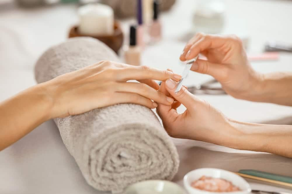 Bàn tay với móng gel chuẩn bị quy trình gỡ gel móng tay chuyên nghiệp tại nhà