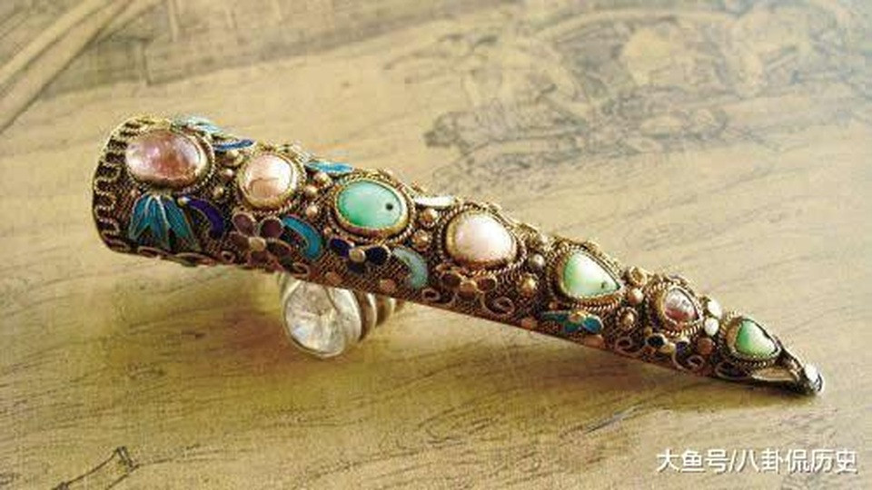 Cận cảnh chi tiết một chiếc hộ giáp vàng khảm đá quý, thể hiện sự cầu kỳ trong chế tác móng giả
