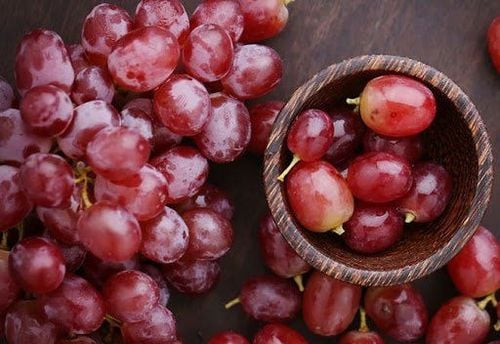 Chùm nho tươi xanh mọng nước, gợi lên ý tưởng về họa tiết lá và đường cong tự nhiên cho bộ nail mộng tây tiêu hoa