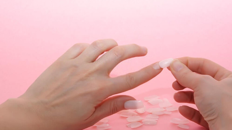 Cô gái trẻ chăm sóc móng tay với lớp sơn gel và phụ kiện, tránh tình trạng móng tay bị xanh
