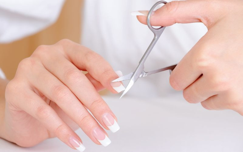 Cô gái trẻ đang phân vân mùng 1 cắt móng chân có sao không khi cầm kềm cắt móng