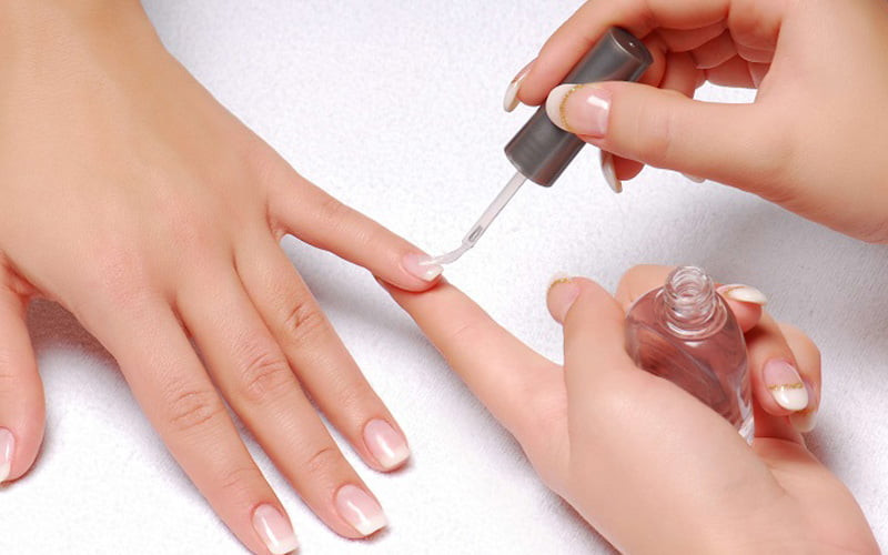Dùng dầu dưỡng ẩm để chăm sóc móng sau khi lấy khoé