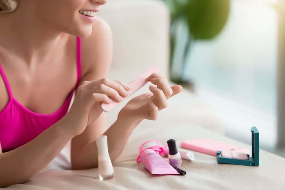 Dùng dũa móng nhẹ nhàng loại bỏ lớp sơn gel cứng, một phương pháp hiệu quả để gỡ gel móng tay