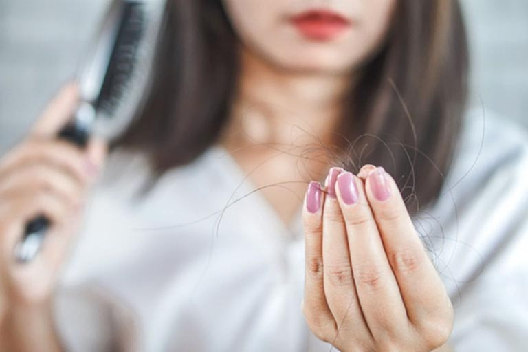 Hình ảnh minh họa tình trạng tóc rụng và móng tay yếu dễ gãy do thiếu chất dinh dưỡng.