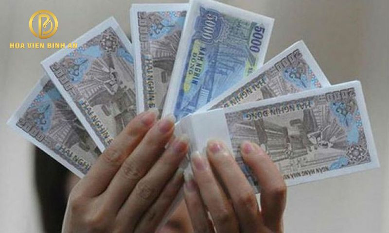 Hình ảnh một người phụ nữ cẩn trọng không nhặt tiền lẻ rơi trên đường, minh họa cho điều kiêng kỵ trong tháng cô hồn