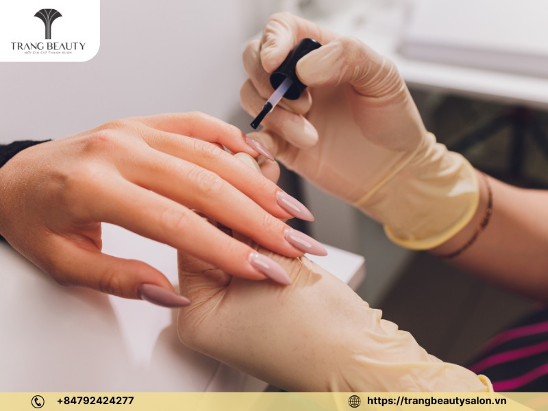 Khách hàng và thợ nail giao tiếp trong salon, thảo luận về lọ sơn móng tay và dịch vụ