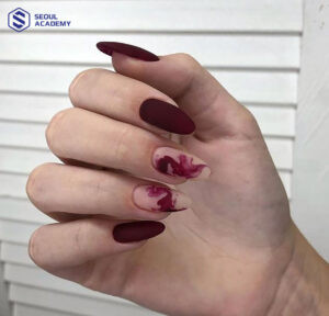 Kiểu nail đỏ mận sơn nhám kết hợp vẽ hoạ tiết lạ mắt, thể hiện phong cách độc đáo