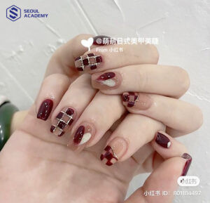 Kiểu nail màu đỏ mận kết hợp hoạ tiết caro trẻ trung và cá tính