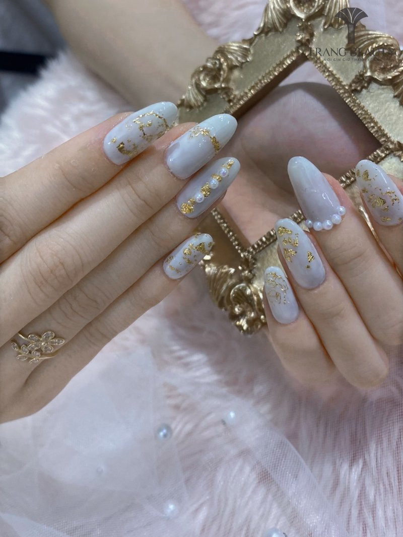 Mảnh vàng lấp lánh trên nền móng tay màu sữa gạo