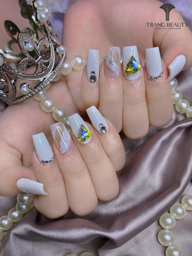 Mẫu móng tay Hàn Quốc đính đá kết hợp với lớp sơn nhũ bạc, tạo hiệu ứng lấp lánh đôi phần cuốn hút.