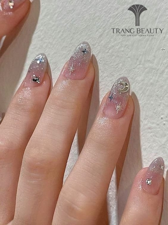 Mẫu móng tay Hàn Quốc đính ngôi sao vàng nhỏ trên nền sơn bóng trong suốt, tạo vẻ đẹp đơn giản mà tinh tế.