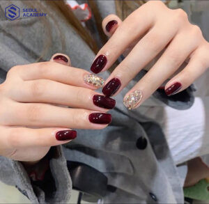 Mẫu móng tay màu đỏ mận kết hợp nhũ vàng to lấp lánh, rất phù hợp cho các buổi tiệc