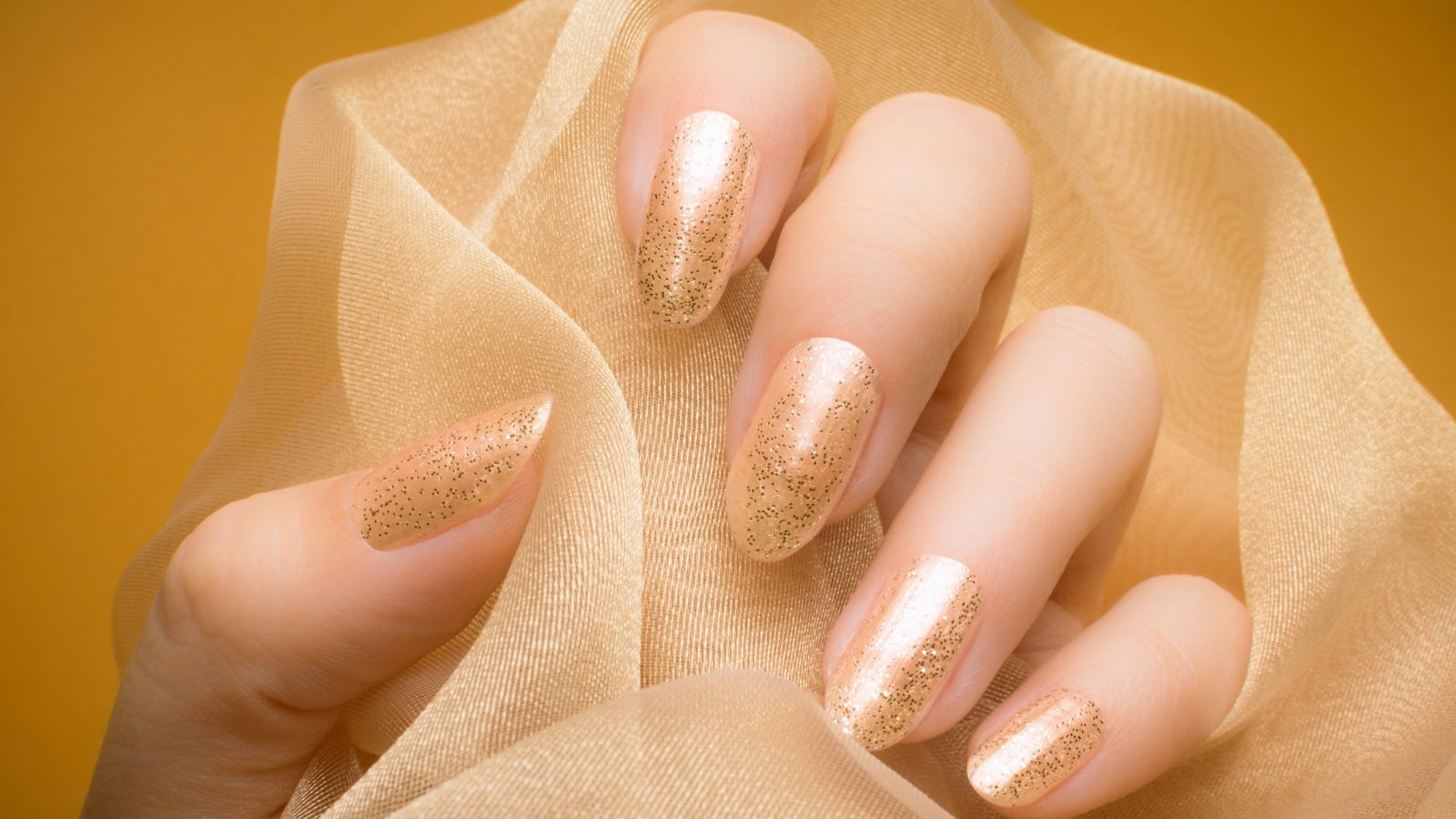 Mẫu móng tay màu hồng nude được phủ nhũ lấp lánh, rất phù hợp cho các dịp lễ hội