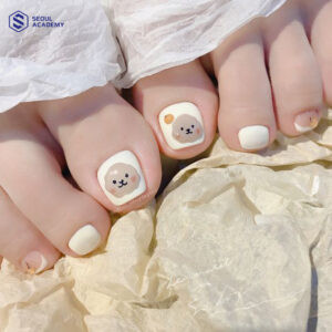 Mẫu nail chân màu trắng vẽ họa tiết gấu dễ thương, mang lại vẻ trẻ trung và đáng yêu cho đôi bàn chân