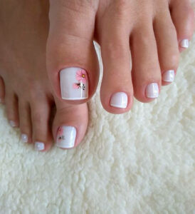 Mẫu nail chân màu trắng vẽ hoa tím nhỏ xinh trên ngón cái, mang đến vẻ đẹp dịu dàng và nữ tính
