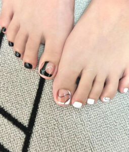 Mẫu nail chân với hai bàn trắng đen đối lập, thể hiện sự cá tính và phong cách độc đáo