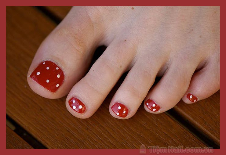 Mẫu nail móng chân màu đỏ đô chấm bi trắng tinh tế