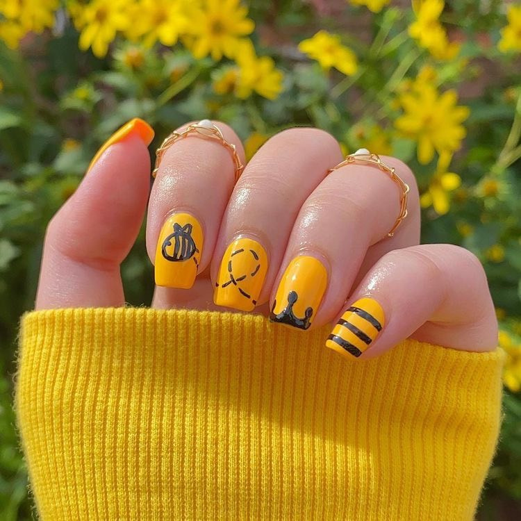 Mẫu nail ong vàng với sọc đen trên nền móng lấp lánh