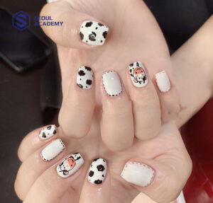 Mẫu vẽ móng tay hình thú với hoạ tiết con bò sữa độc đáo trên nền móng trắng