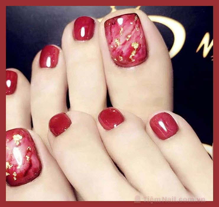 Móng chân màu đỏ cherry với họa tiết hoa trắng thanh lịch