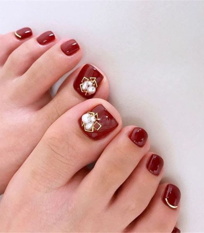 Móng chân màu đỏ mận cá tính cho chuyến đi biển
