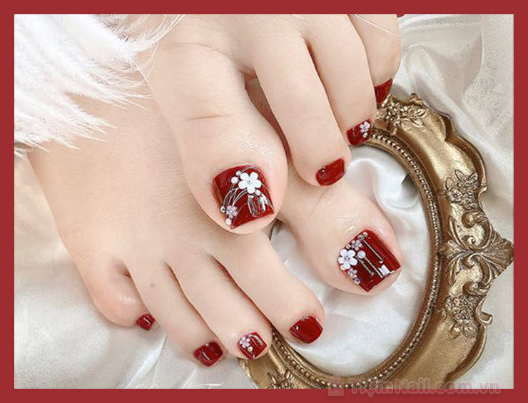Móng chân màu đỏ tươi vẽ hoa cúc trắng tinh tế