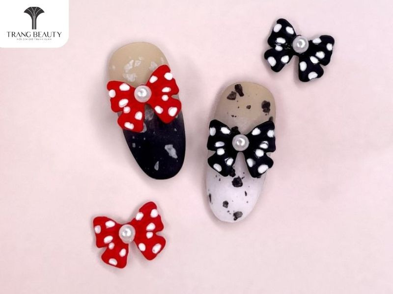 móng tay đính charm nơ đỏ pha đen cá tính