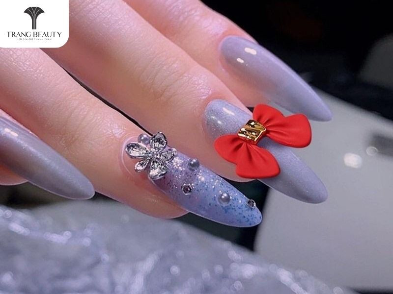 móng tay đính charm nơ đỏ sang trọng với nơ kim loại vàng và đá