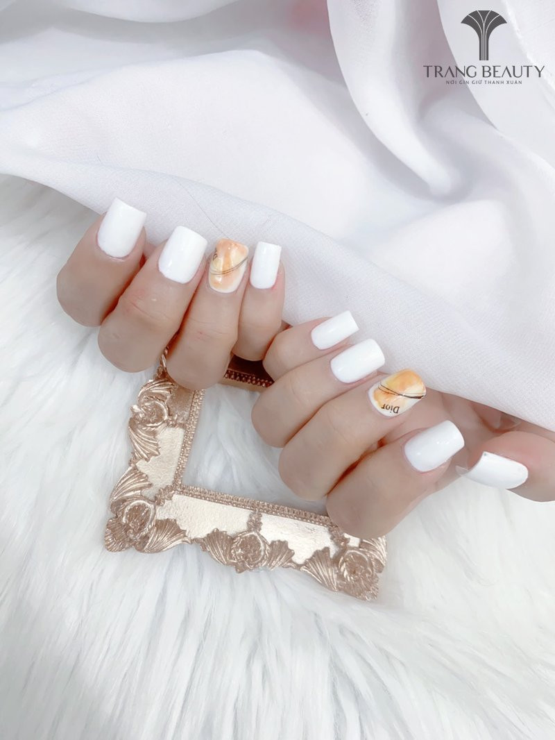 Móng tay màu gạo dáng ngắn được tô điểm bằng một vài chiếc nail loang màu