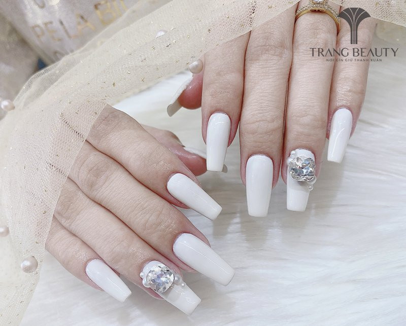 Móng tay màu trắng gạo dáng vuông dài kết hợp đính đá nhỏ, tạo vẻ sang trọng và cá tính