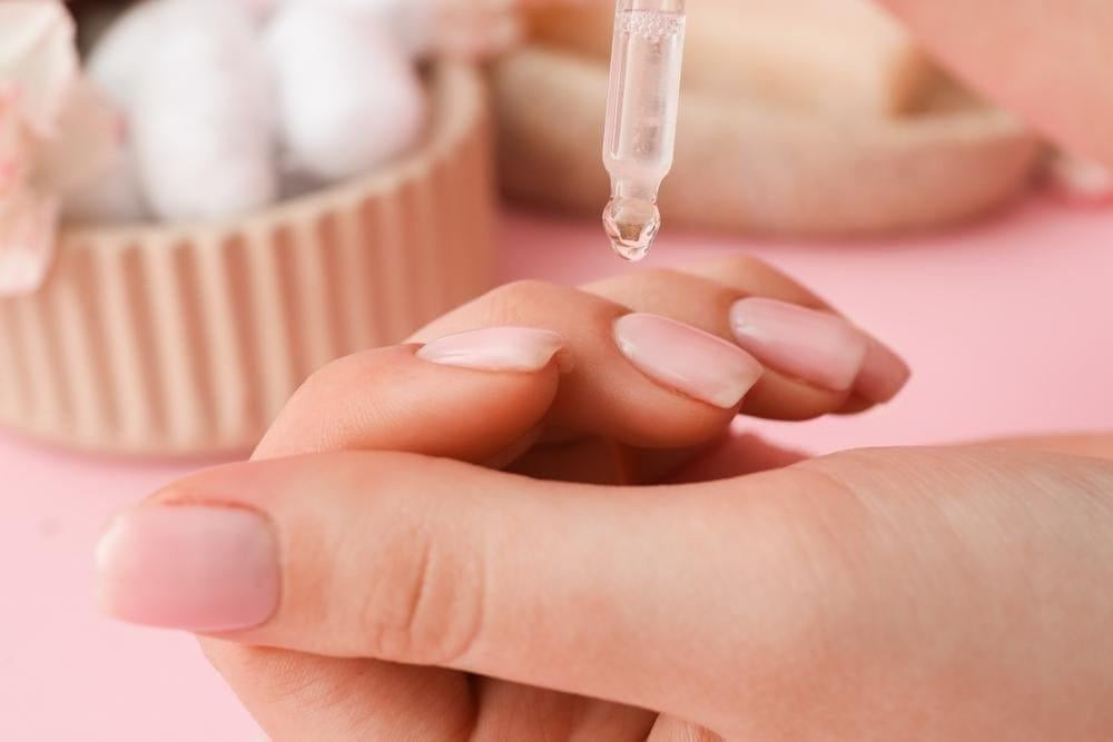 Một bác sĩ đang kiểm tra móng tay của bệnh nhân, đưa ra lời khuyên về hiện tượng sọc trên móng tay