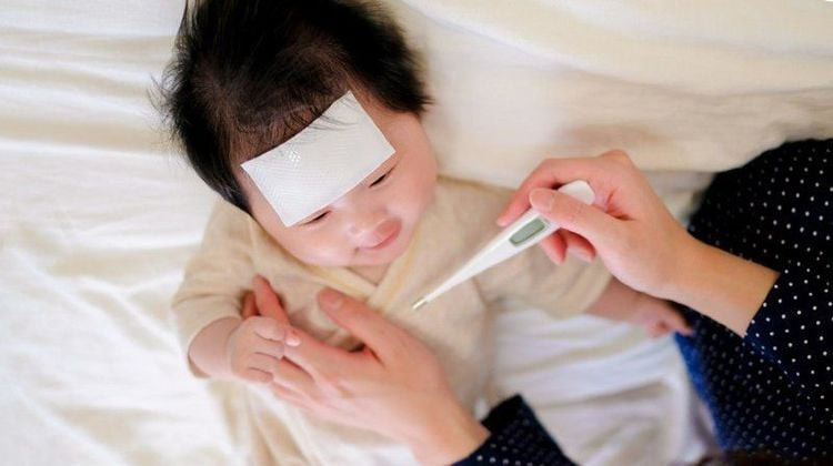 Một đứa trẻ đang được kiểm tra nhiệt độ, với hình ảnh ẩn dụ về việc sốt hoặc mưng mủ sau khi dằm đâm vào móng tay, cần được đưa đến bác sĩ