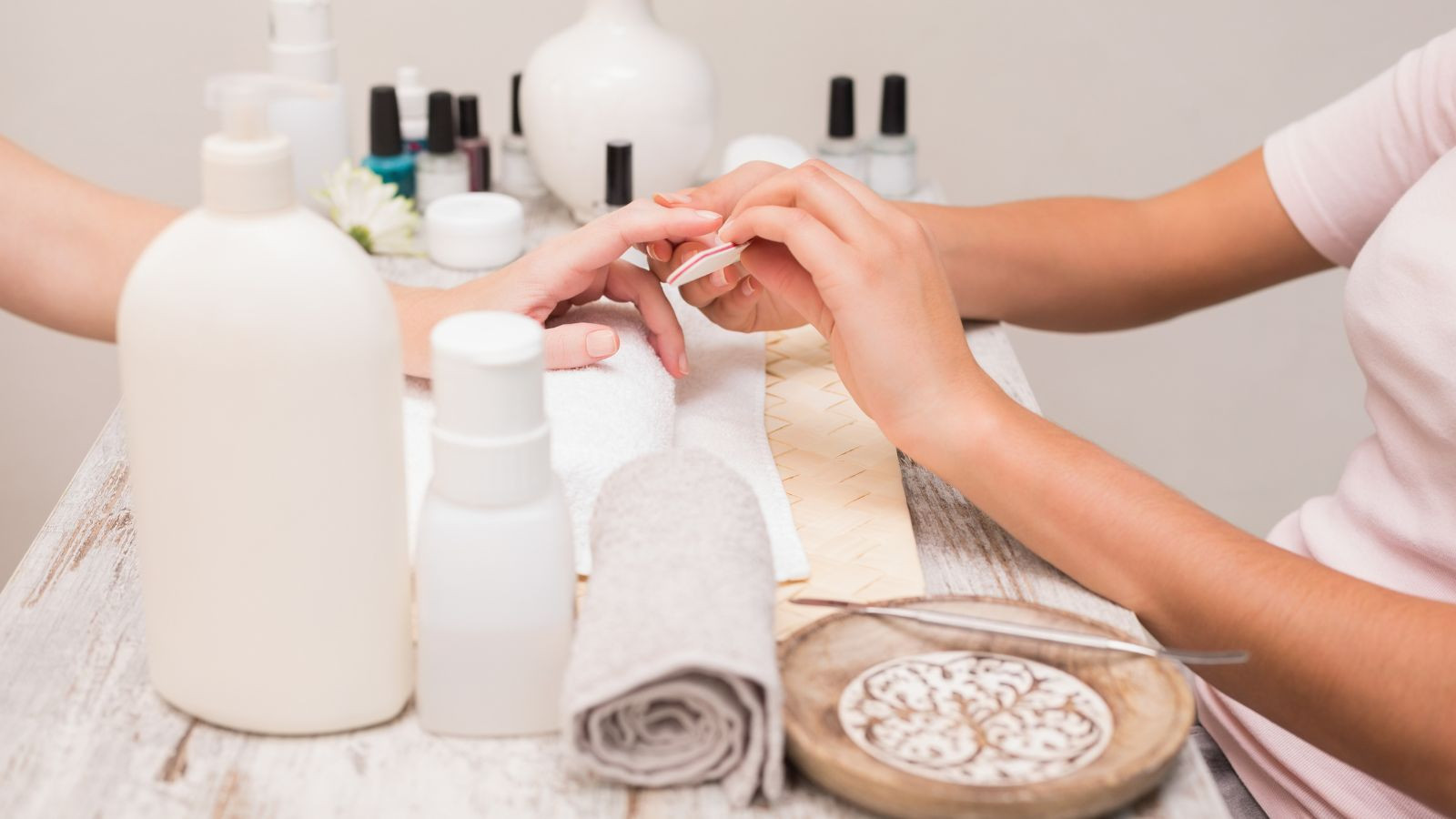 Một người phụ nữ trẻ mỉm cười với bàn tay được làm nail đẹp, biểu tượng của ý nghĩa tích cực mà tên tiệm nail tiếng Anh mang lại