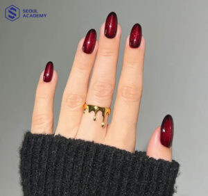 Nail mắt mèo màu đỏ mận cực kỳ tôn da và sang chảnh, tạo hiệu ứng ánh sáng cuốn hút
