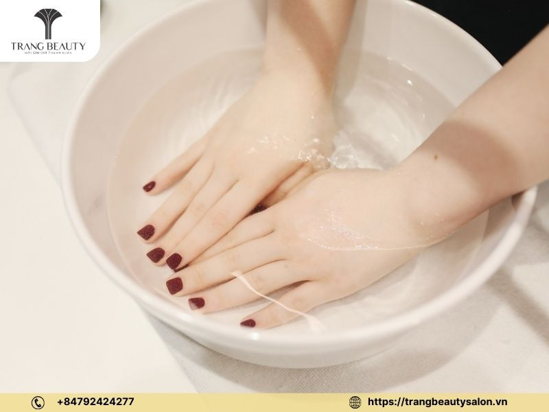 Ngâm móng tay bằng nước ấm trước khi vẽ móng