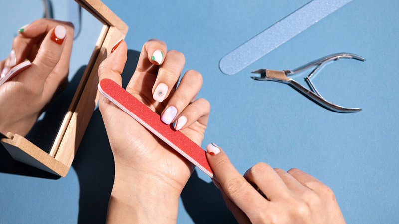 Dũa Móng Tay Có Hại Không? Sự Thật Từ Chuyên Gia Ảnh Nail Người đàn ông đang cẩn thận dũa móng tay bằng dụng cụ chuyên dụng, thể hiện sự tỉ mỉ trong quá trình chăm sóc móng