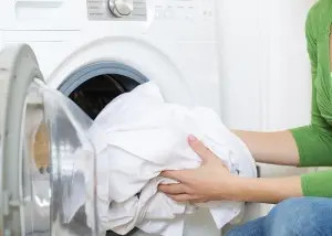 Người dùng bỏ quần áo đã xử lý vết bẩn vào máy giặt