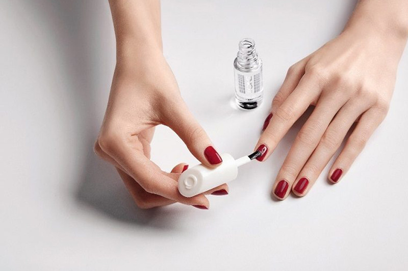 Người mẹ bầu đang suy nghĩ về việc sơn móng tay gel, đặt ra câu hỏi về sự an toàn khi làm đẹp móng trong thai kỳ.