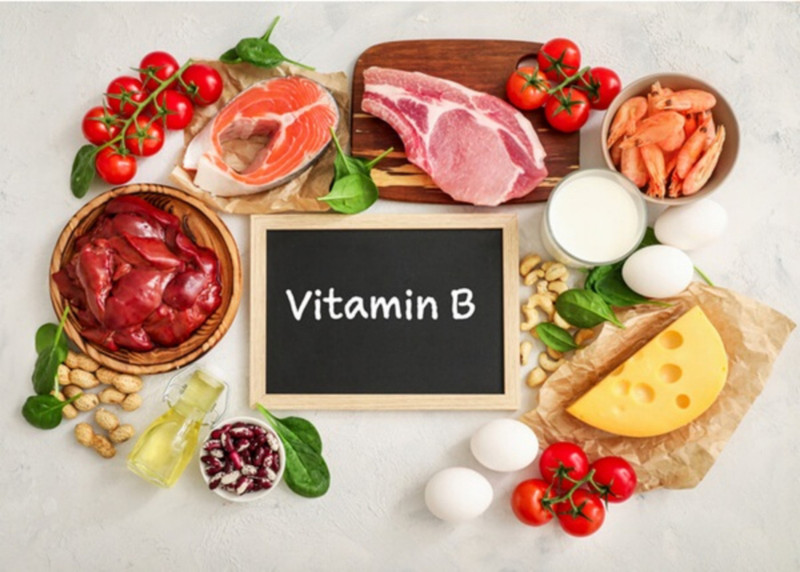 Người phụ nữ đang cầm viên thuốc bổ sung vitamin B, hỗ trợ khắc phục tình trạng móng tay mềm, dễ gãy.