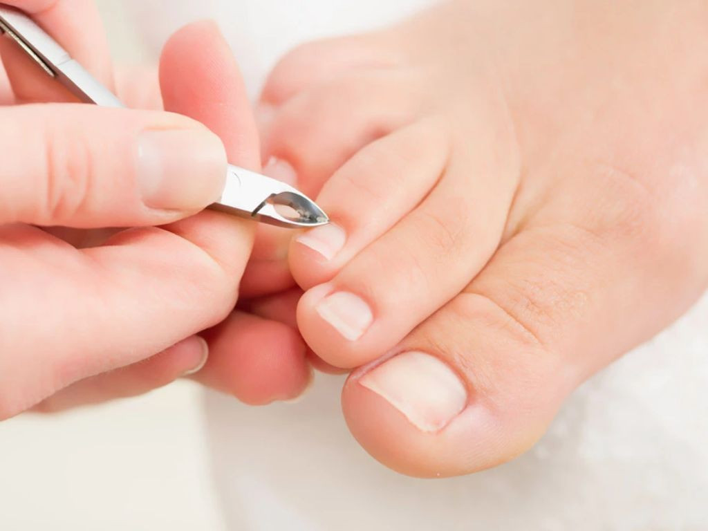 Người phụ nữ đang chăm sóc móng chân, liên quan đến quan niệm kiêng kỵ mùng 1